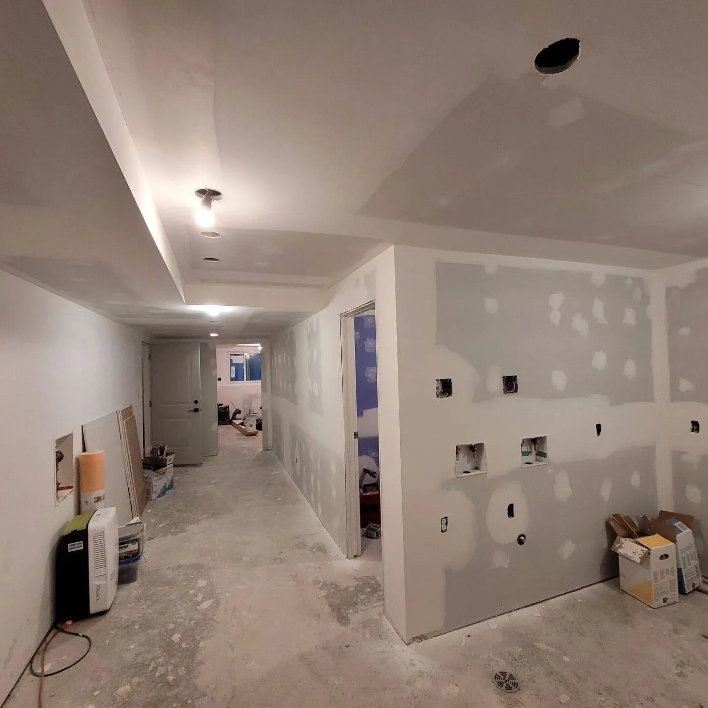 A room with walls being remodeled and a wall in the middle